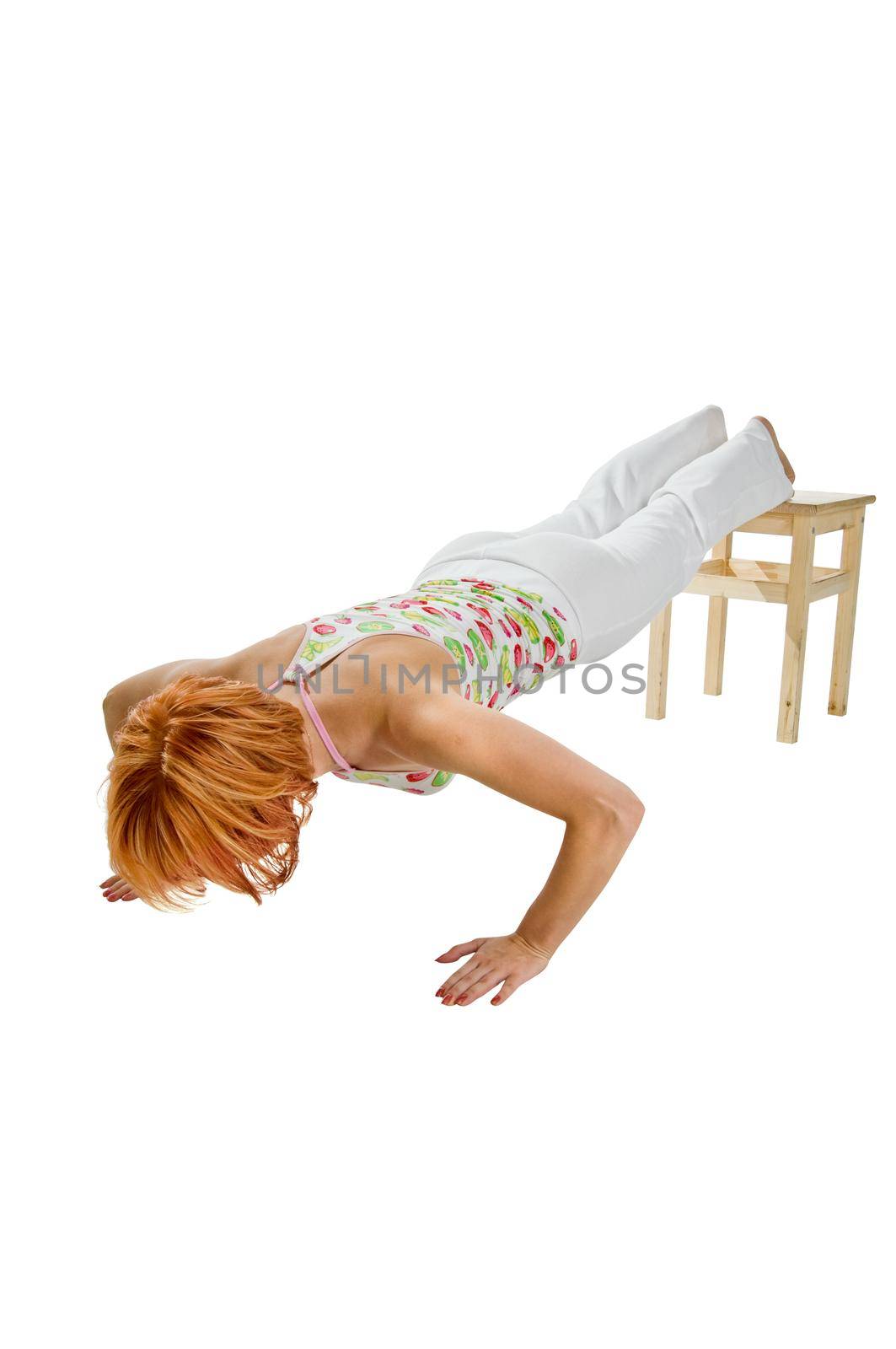 Red haired girl performing fitness exercises on white background