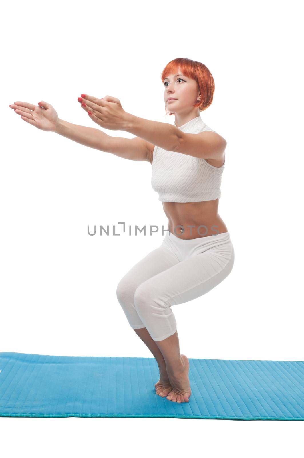 Beautiful red-haired girl practicing yoga or callanetics on white background