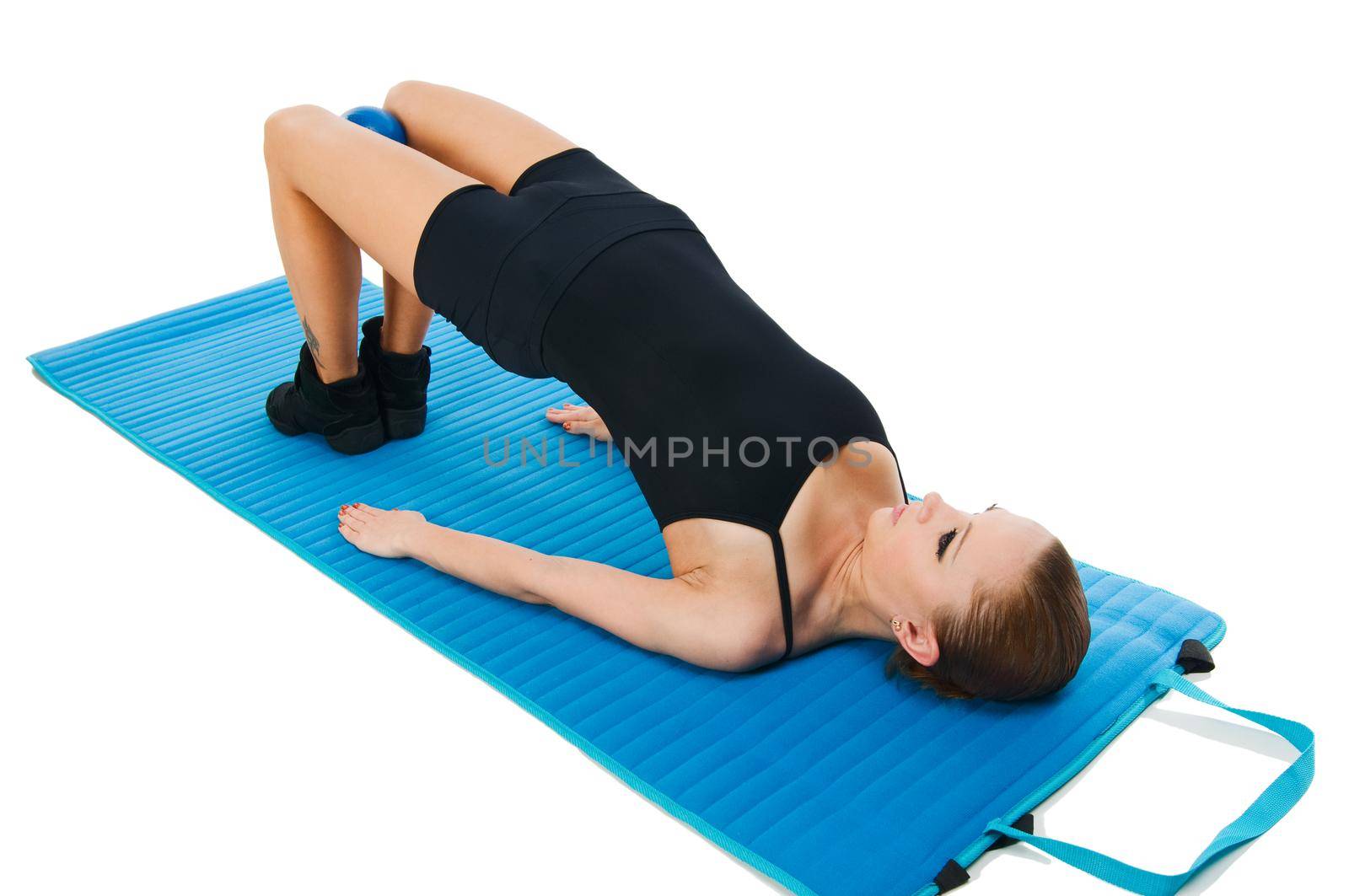 Beautiful fit red girl practicing pilates or callanetics with ball and blue yoga mat