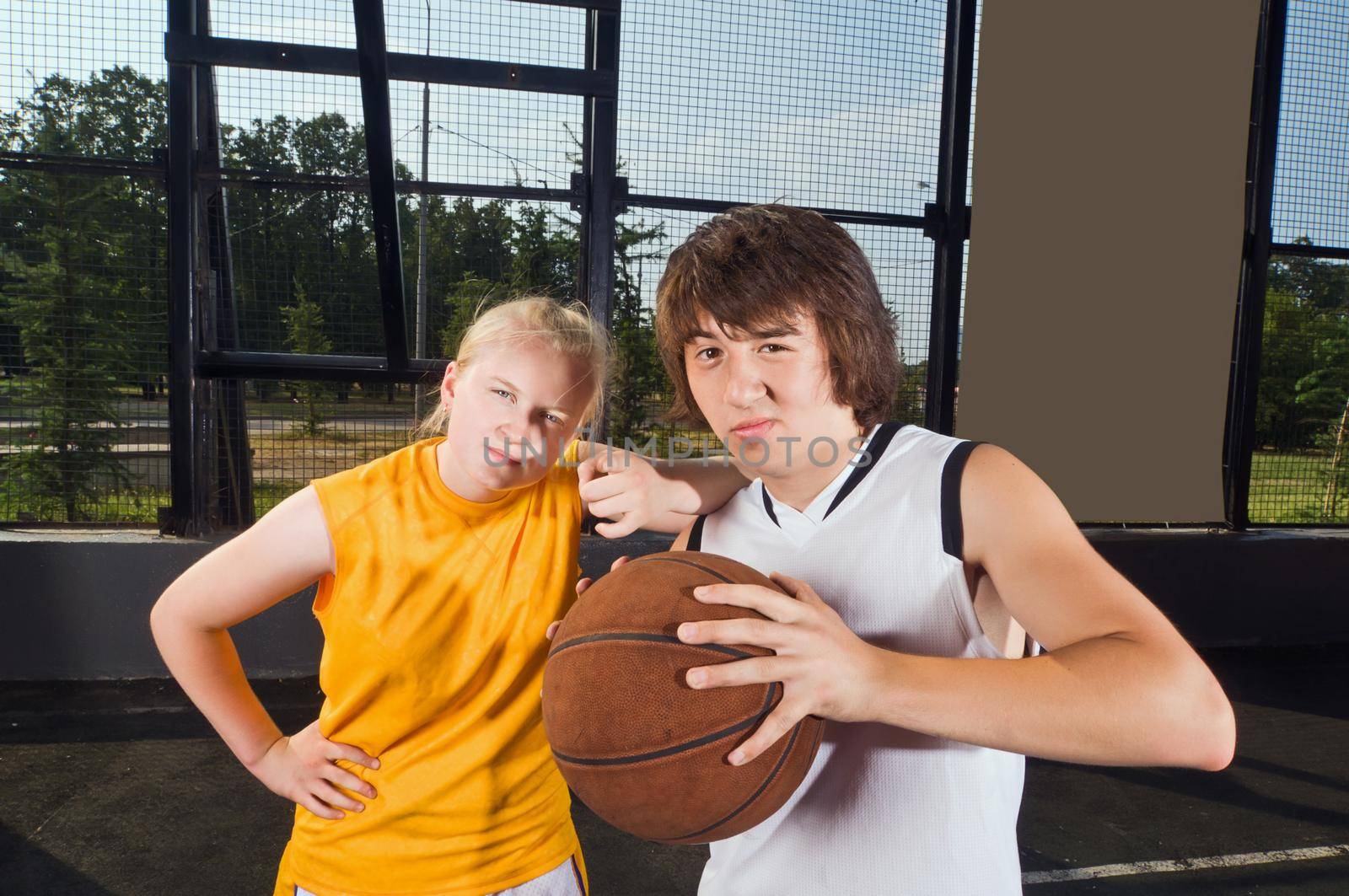 Two teenage basketball players posing at the outdoor playground