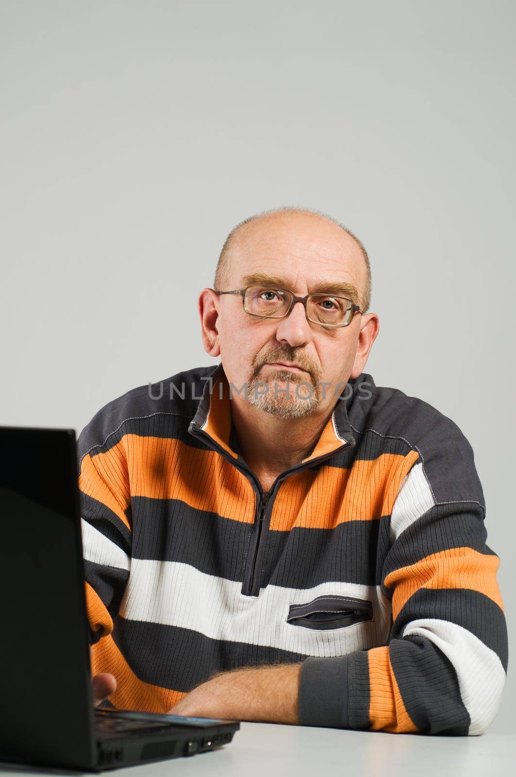 Mature man sitting at the table with laptop