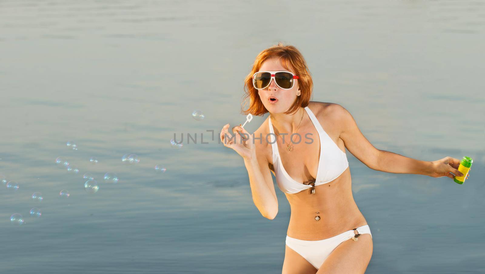 Sensual girl with soap bubbles at the beach by nikitabuida