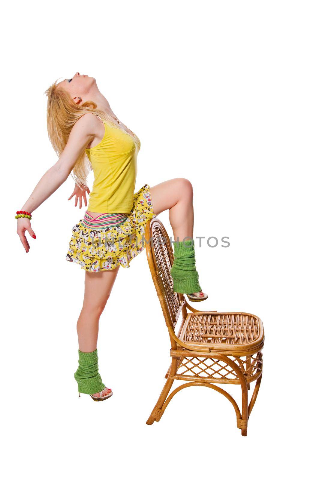 Beautiful stripper wearing yellow dress dancing with the chair isolated on white background