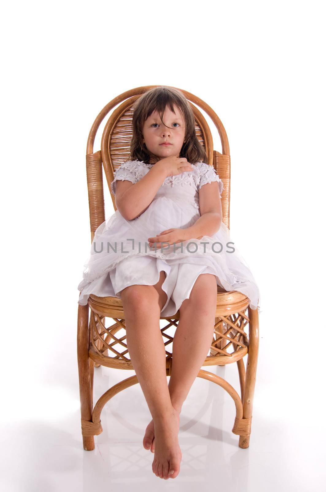 Portrait of a little girl sitting on a big chair