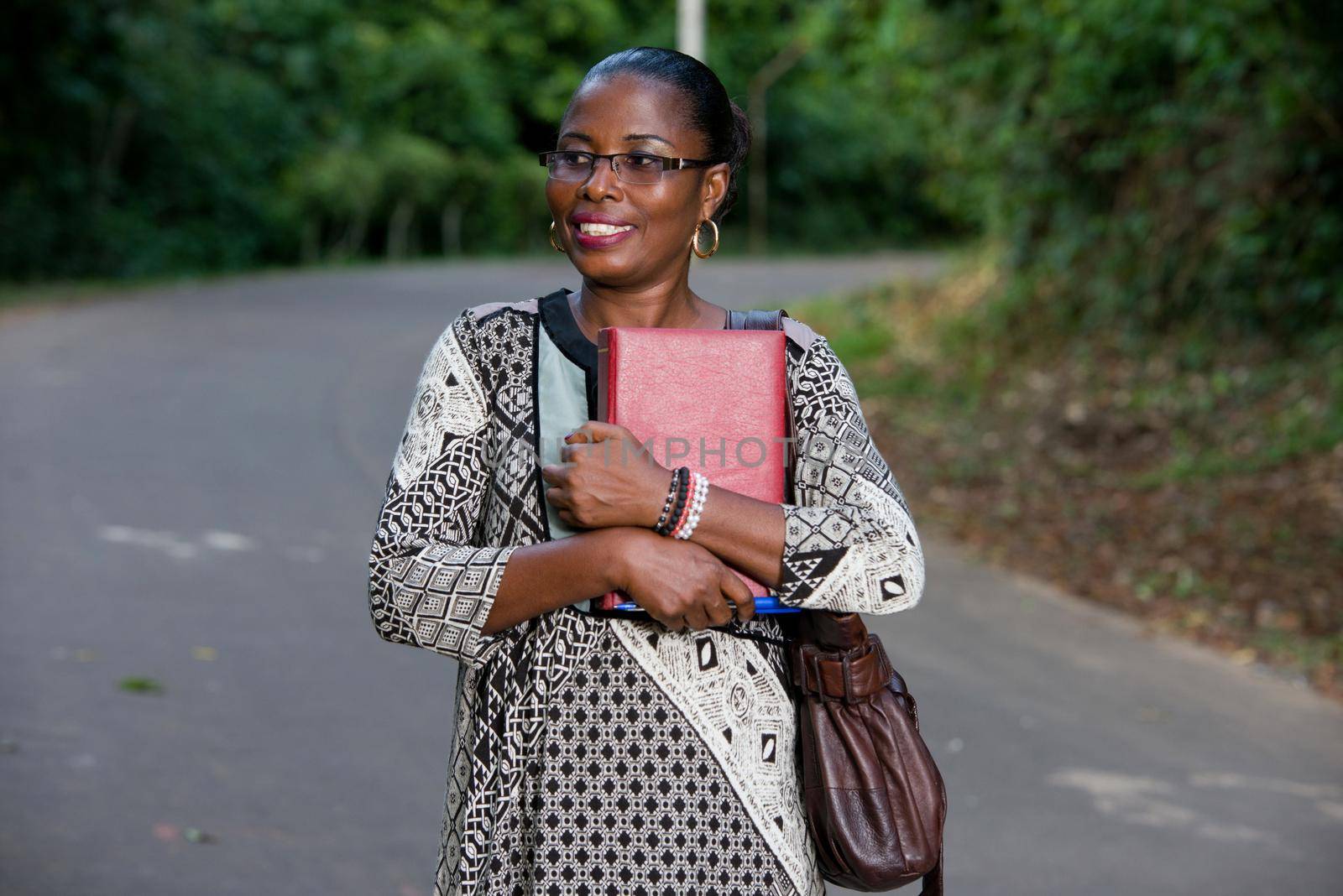 young woman standing in black pants camisole and pound against the chest going to look in profile while smiling.