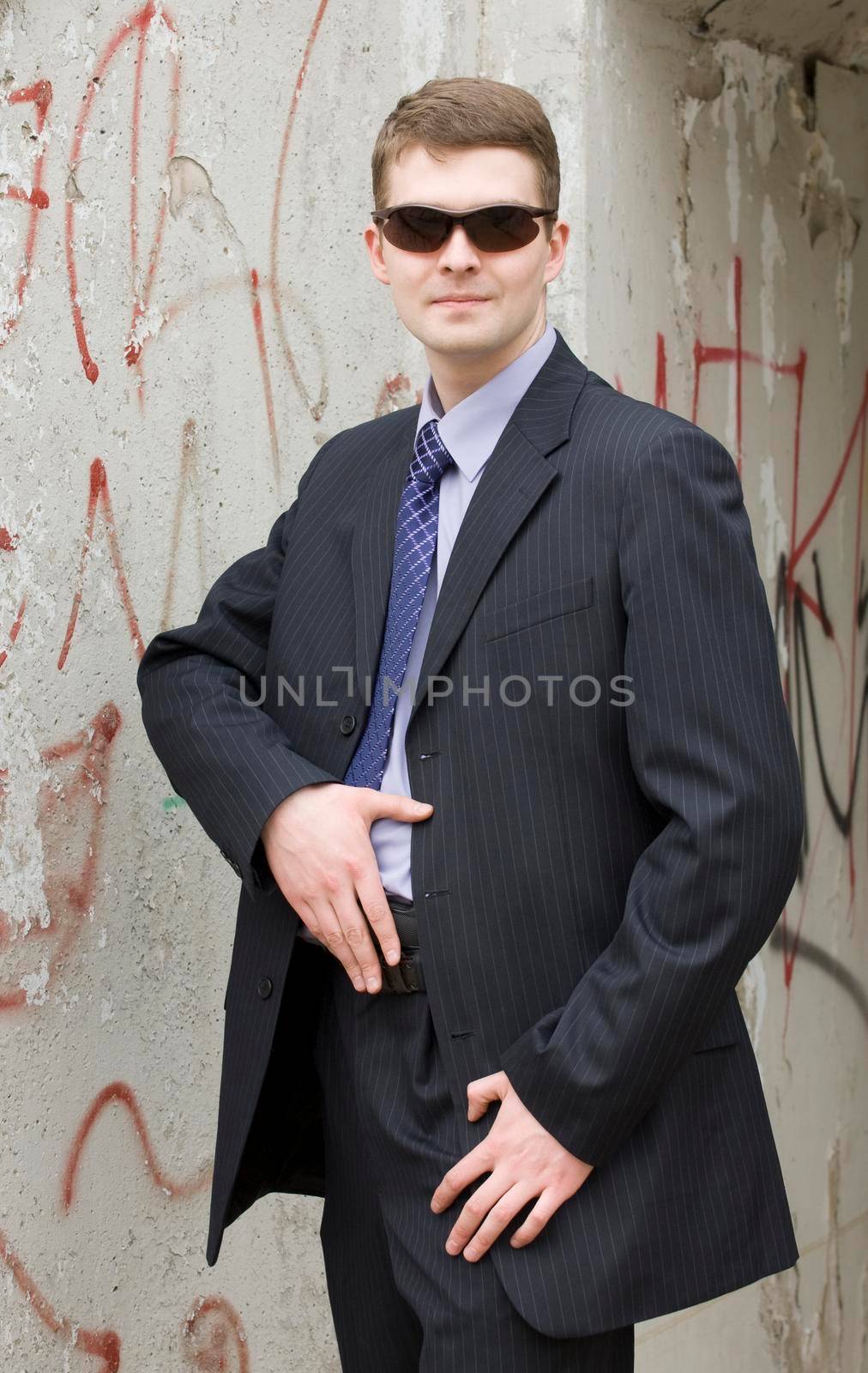 Gangster or security man is ready to pull the gun from behind a belt.
