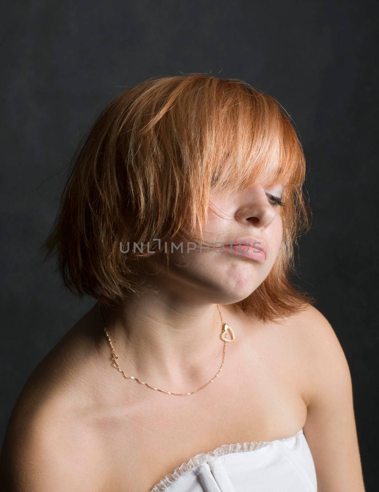 Portrait of a beautiful red haired girl on black background