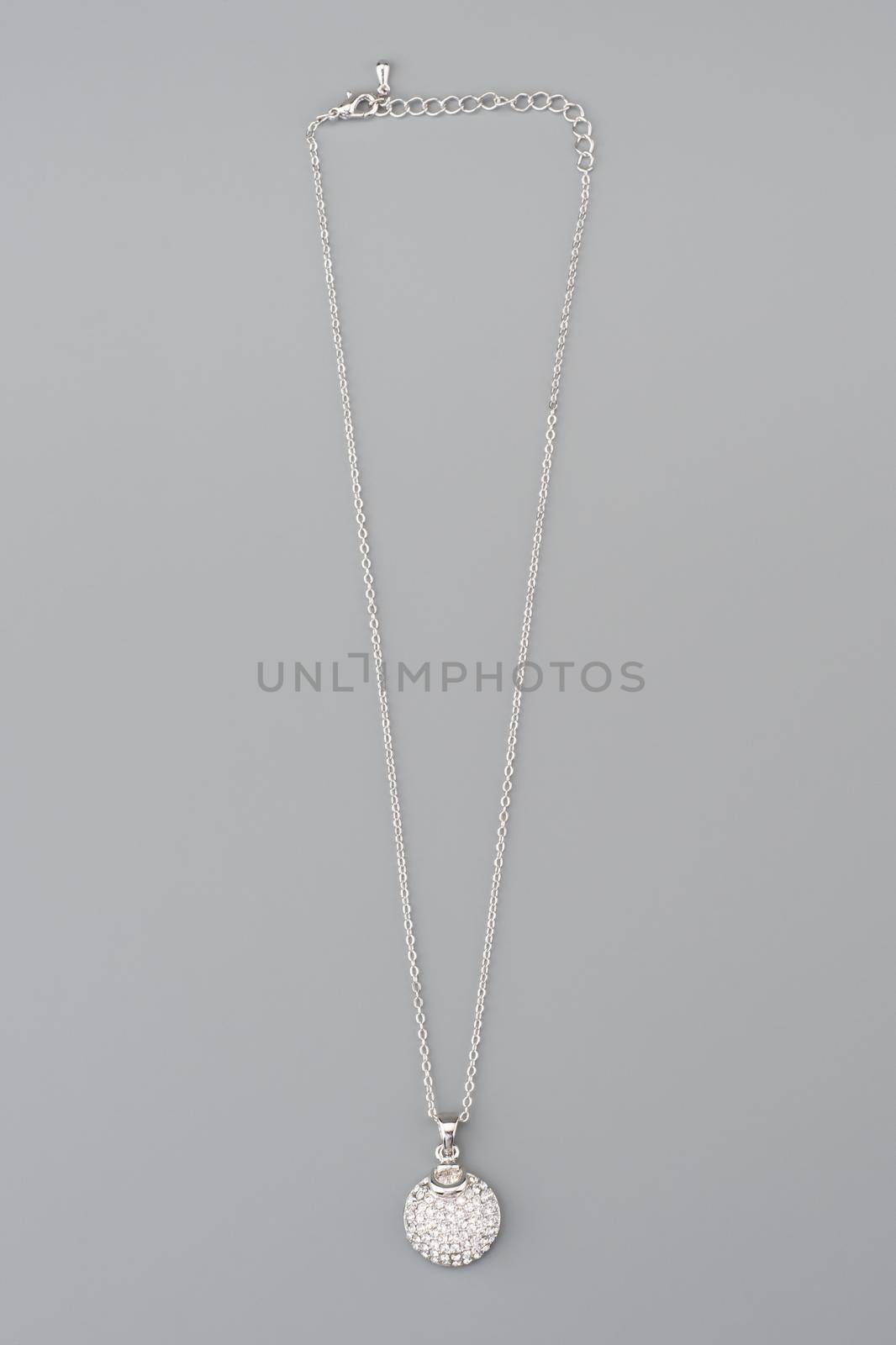 Silver necklace with pendant shot on gray background