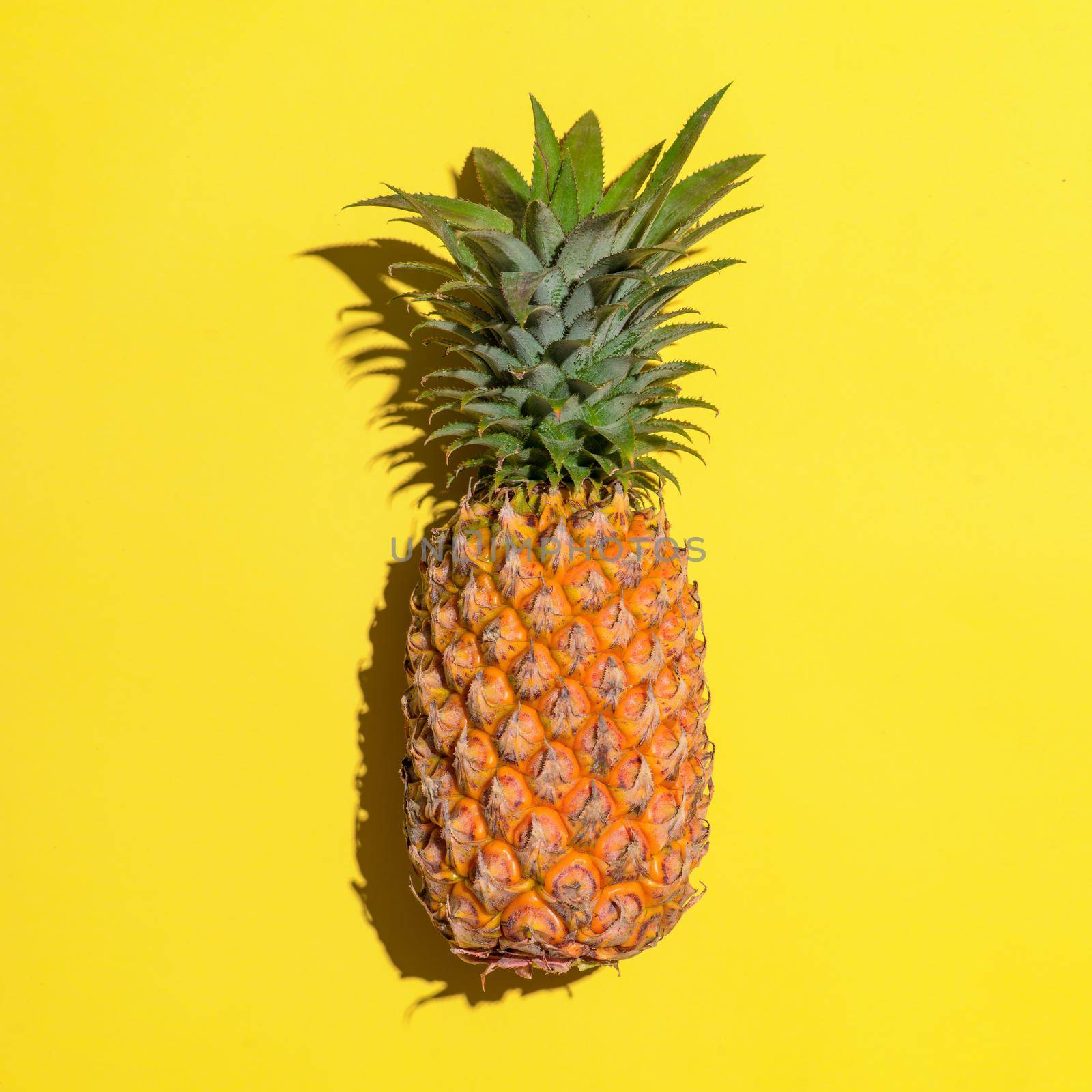 Summer fruit. Pineapple on bright yellow background. by makidotvn