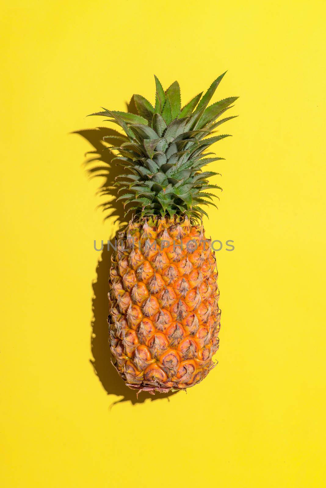 Summer fruit. Pineapple on bright yellow background.