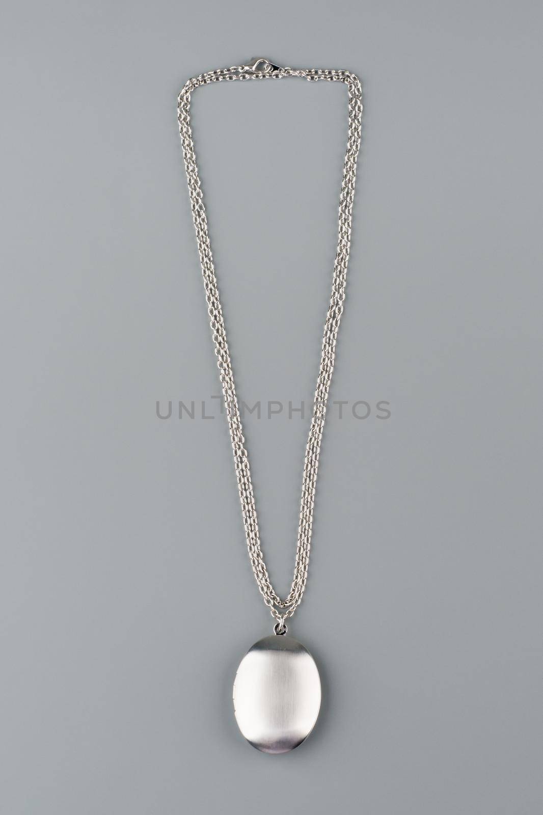 Silver necklace with pendant shot on gray background