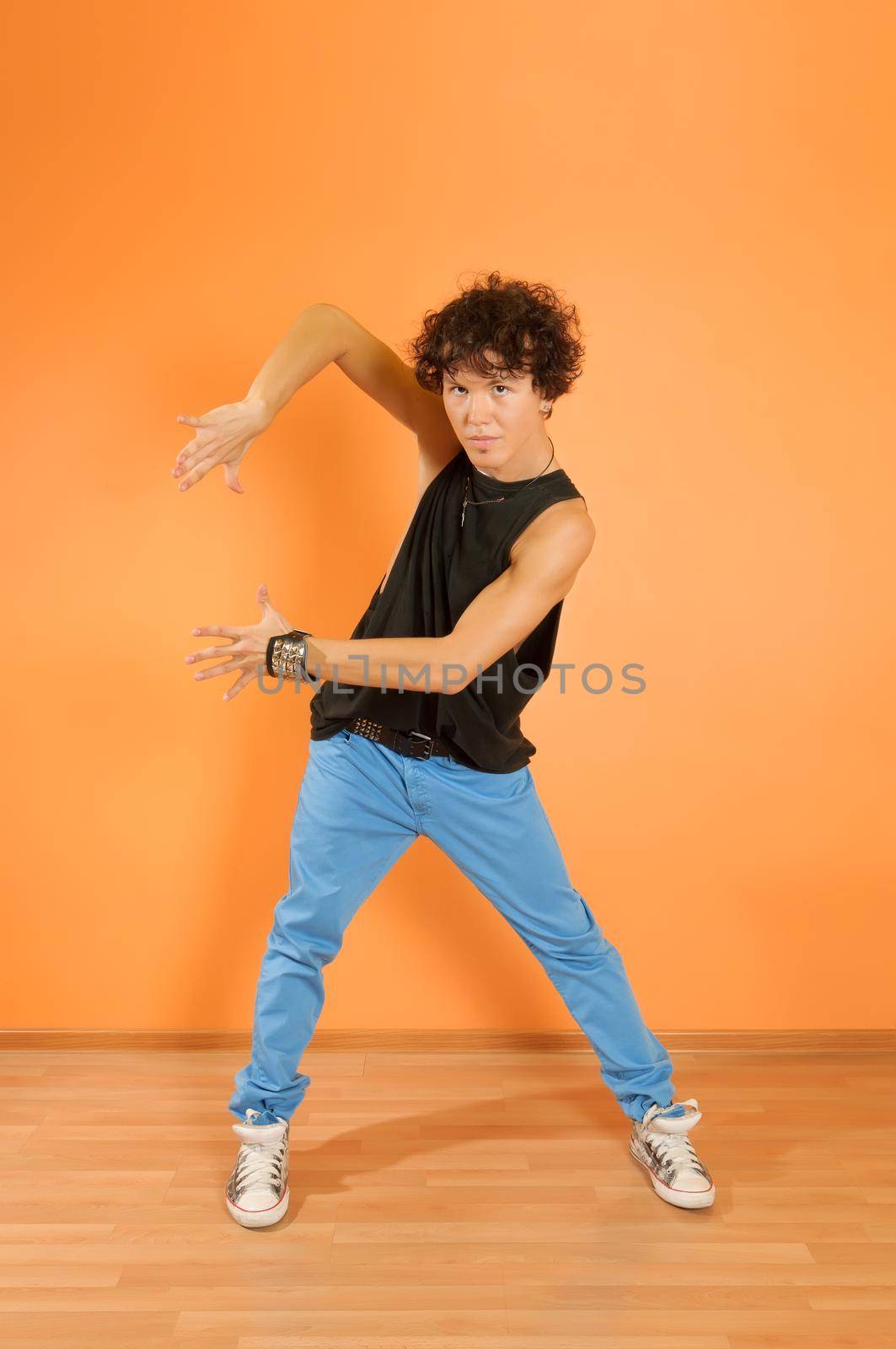 Young man perform break dancing moves on vivid background
