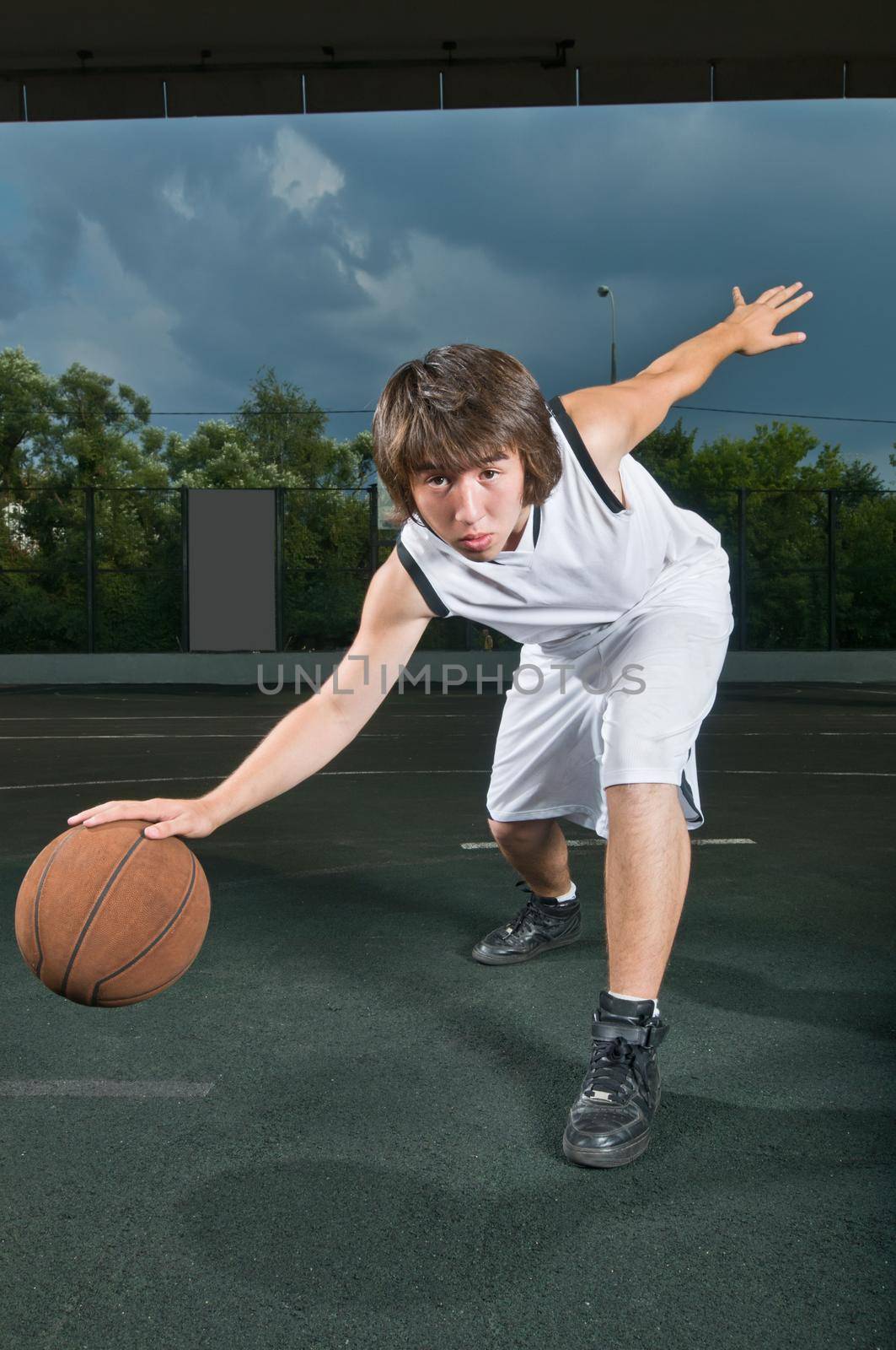 Teenage basketball player showcasing his ballhandling skills