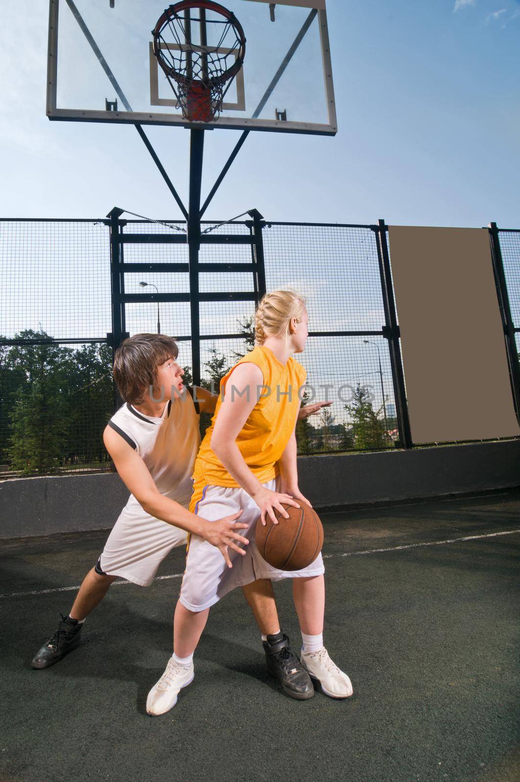 Teenagers playing basketball by nikitabuida