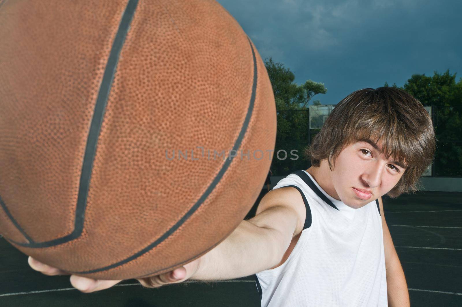 Teenager with basketball at the street playground