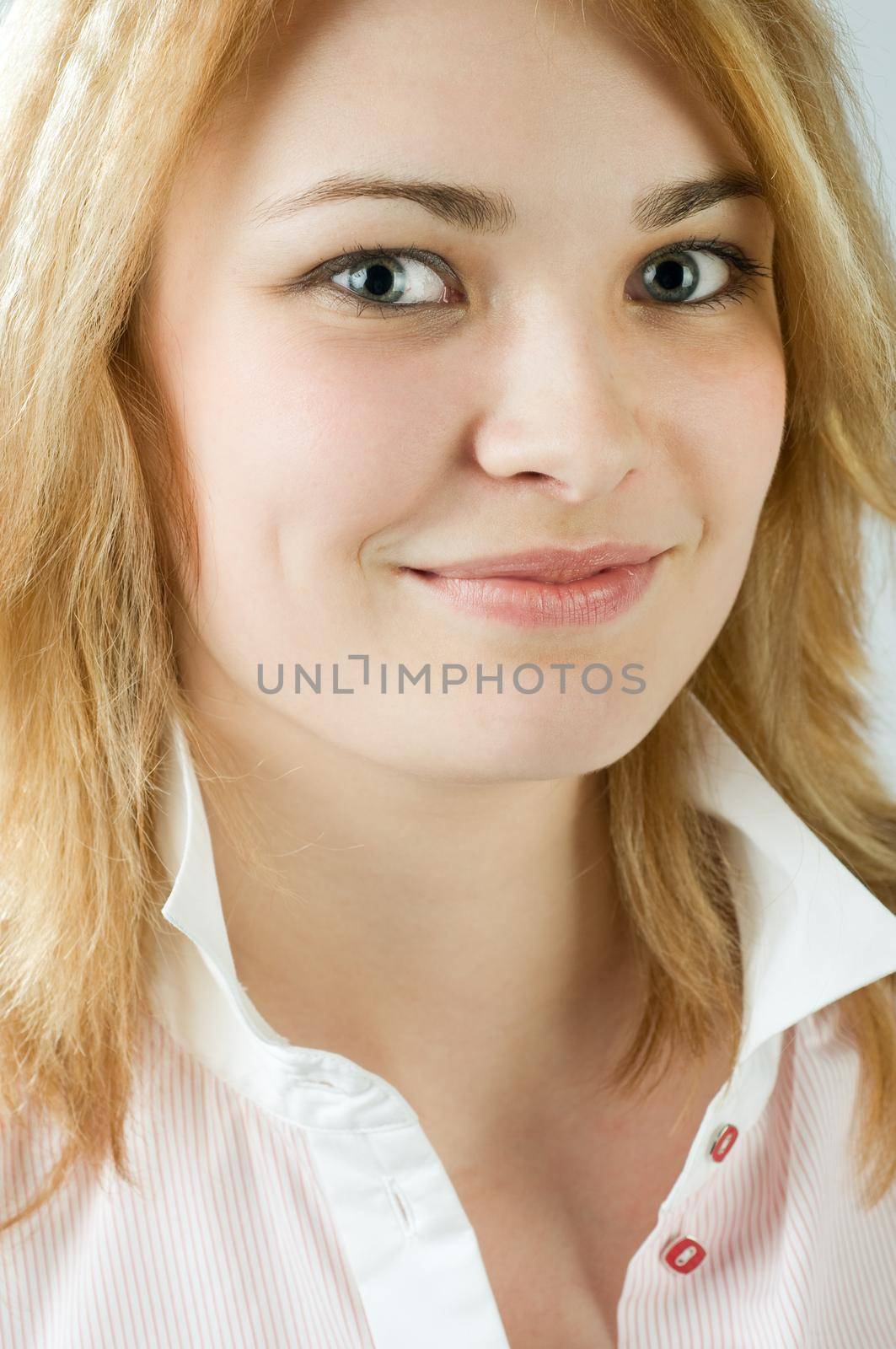 Portrait of a beautiful blond girl at the studio smiling