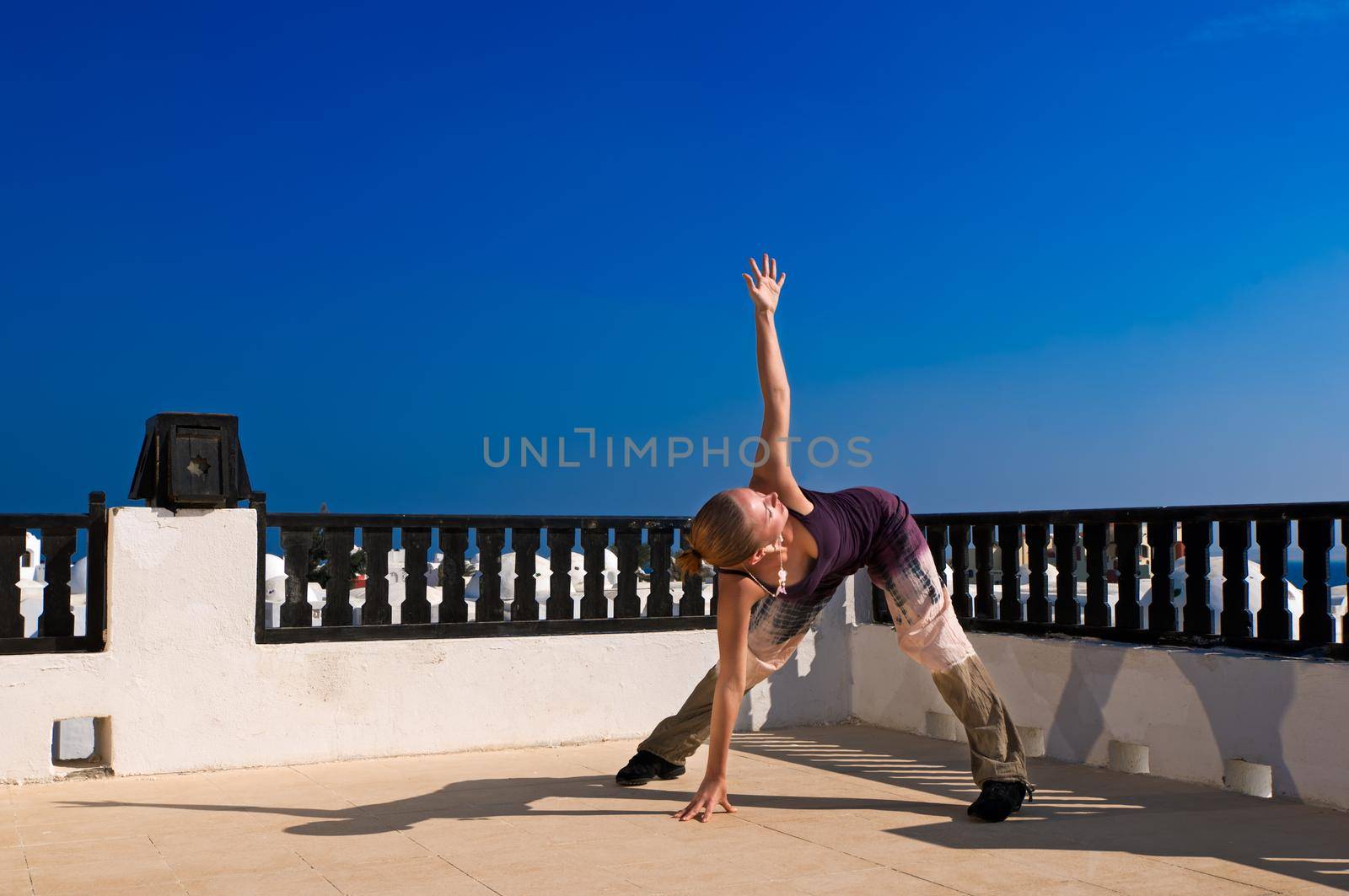 Attractive redhair woman practicing Vinyasa yoga outdoors