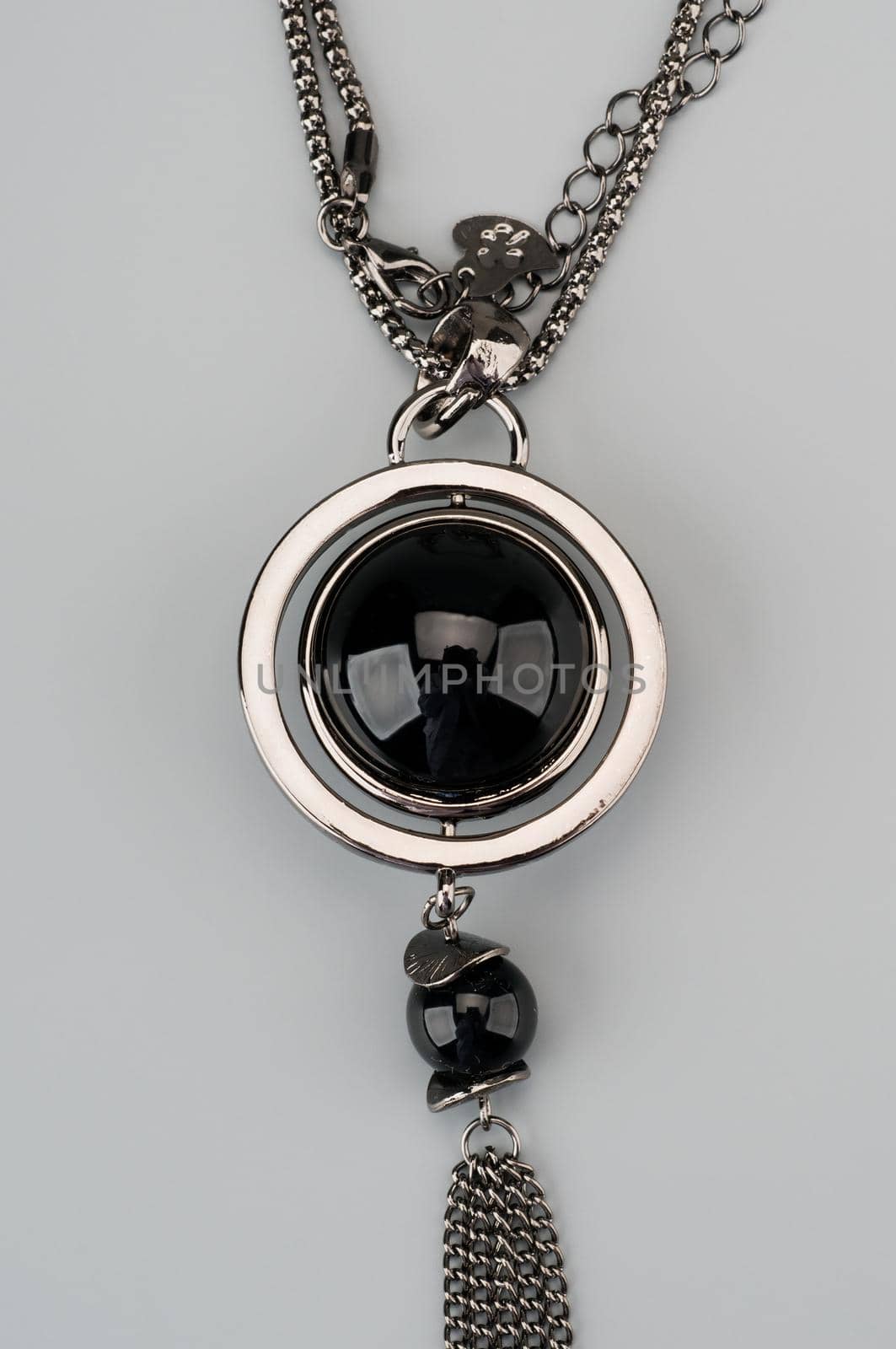 Silver necklace with pendant shot on gray background