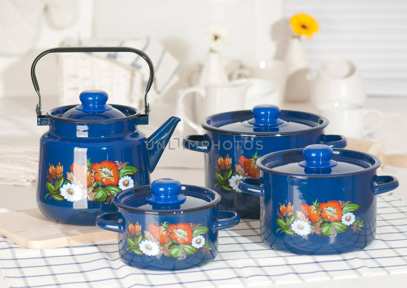 Kitchen utensil set of blue pots and kettle arranged on a table