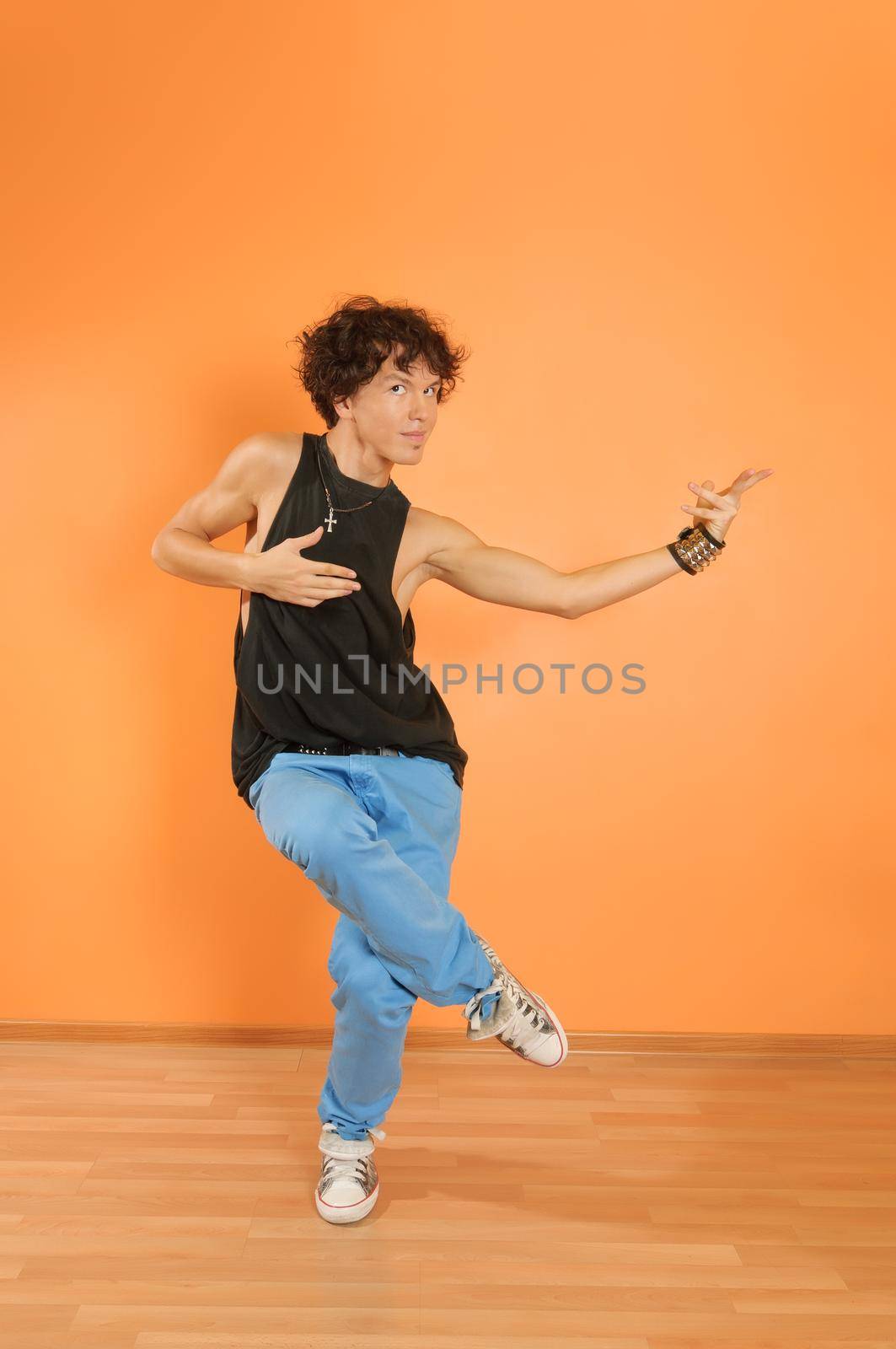 Young man perform break dancing moves on vivid background