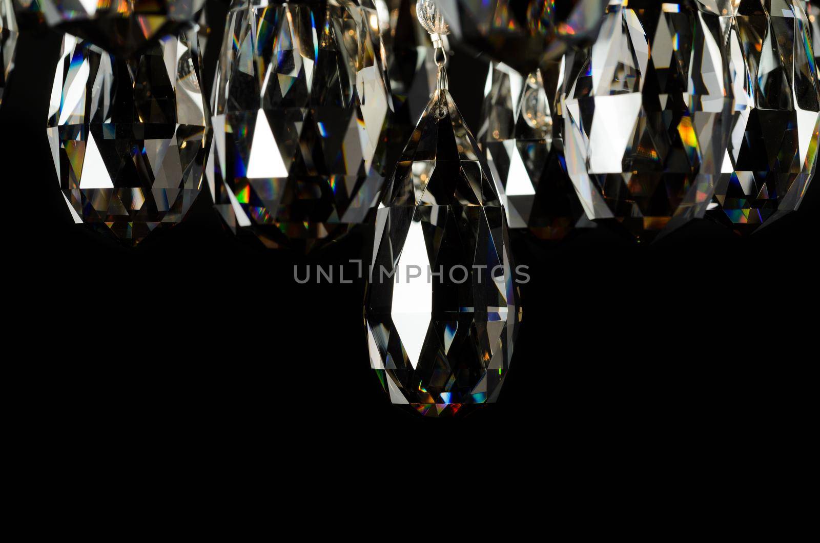 Contemporary glass chandelier crystals isolated over black background