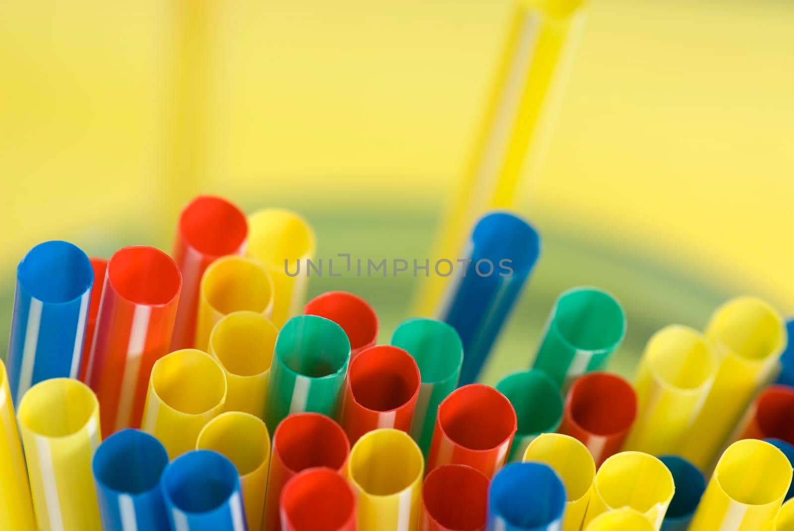 Bunch of colorful drinking straws on a bright background