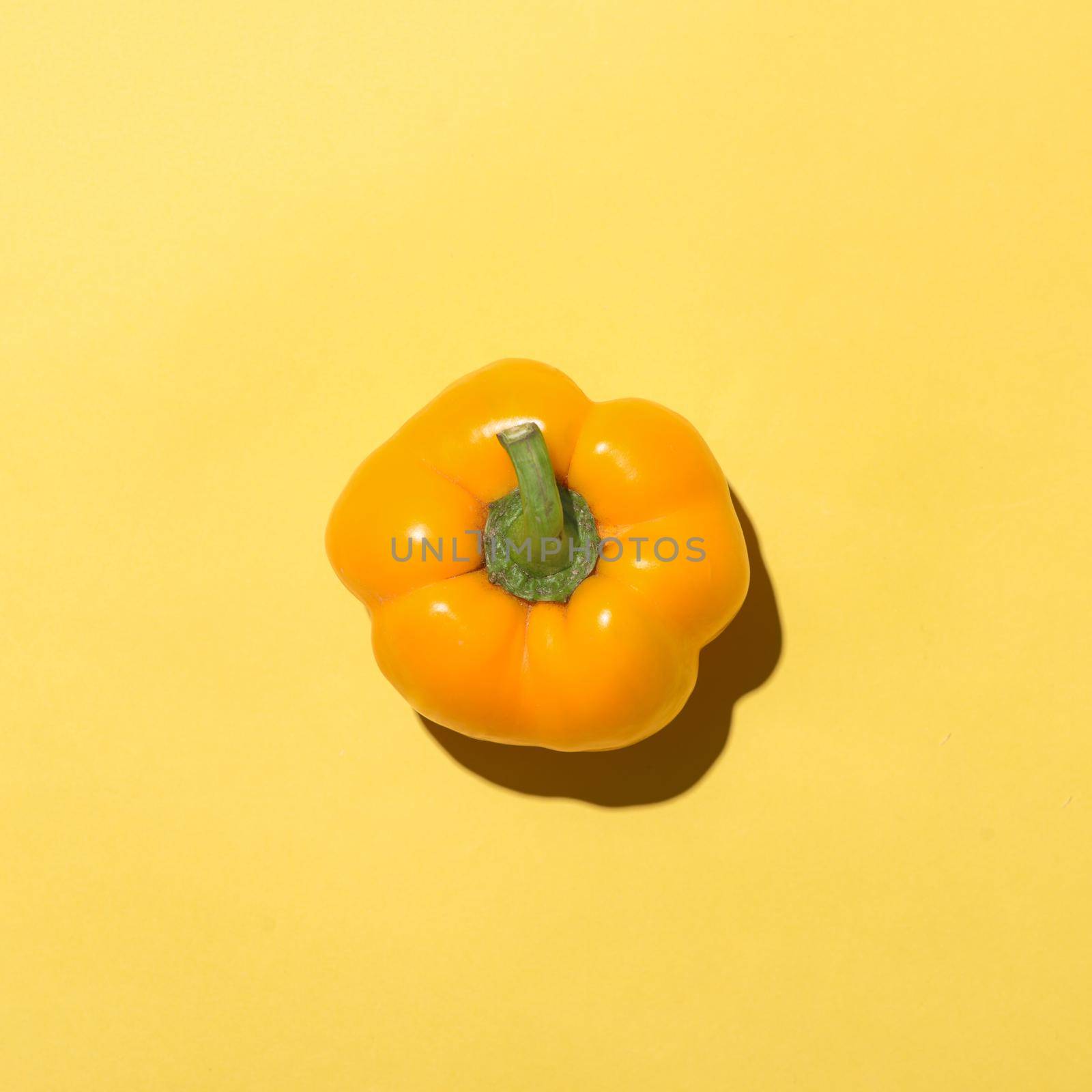 Top view of yellow bell pepper on yellow background. 