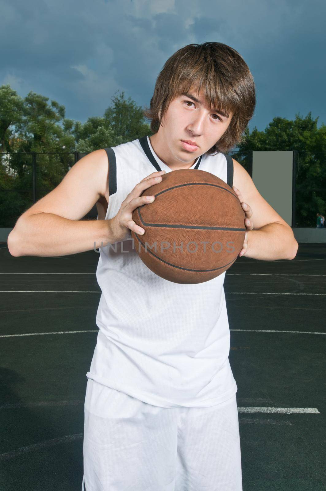 Teenage basketball player holding the ball ready to pass