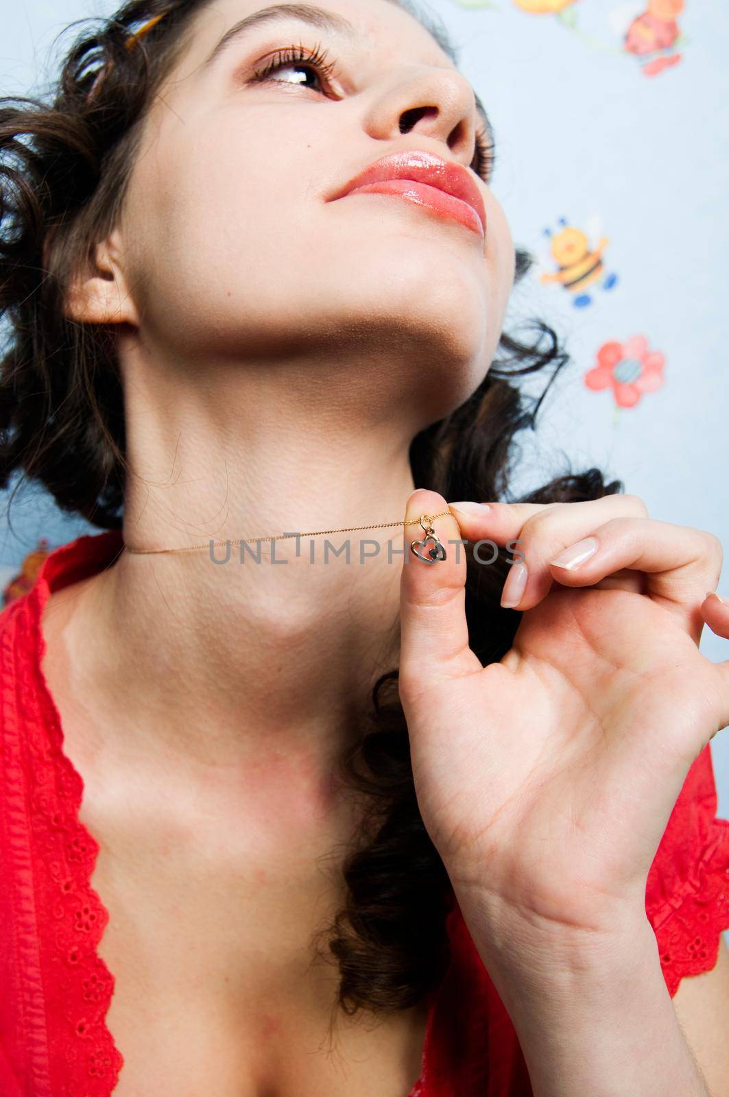 Girl holding heart-shaped pendant thinking about her love