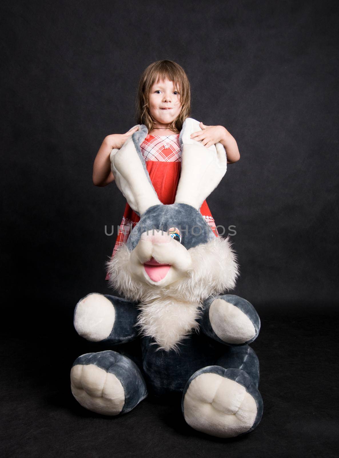 Little girl playing with a toy bunny