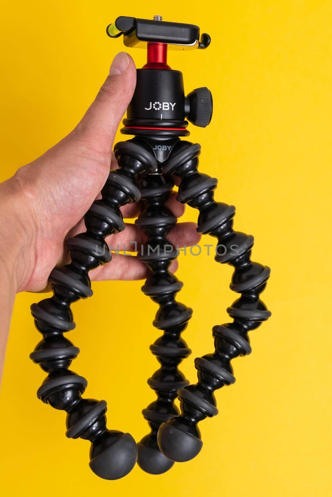 Tyumen, Russia-June 21, 2021: A joby tripod on a yellow background. Selective focus by darksoul72