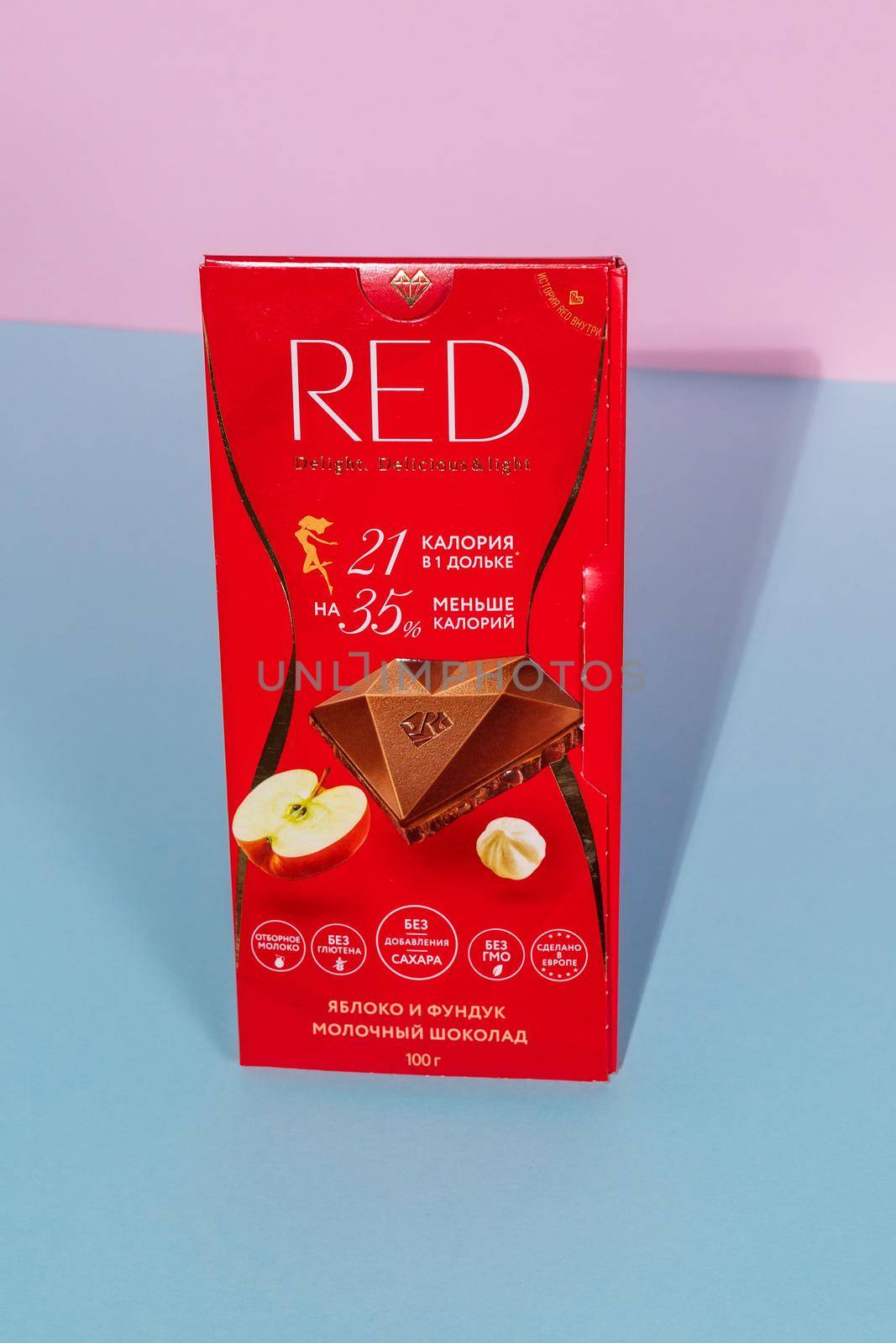 Tyumen, Russia-August 06, 2021: Red milk chocolate with hazelnuts and apple. Vertical photo by darksoul72