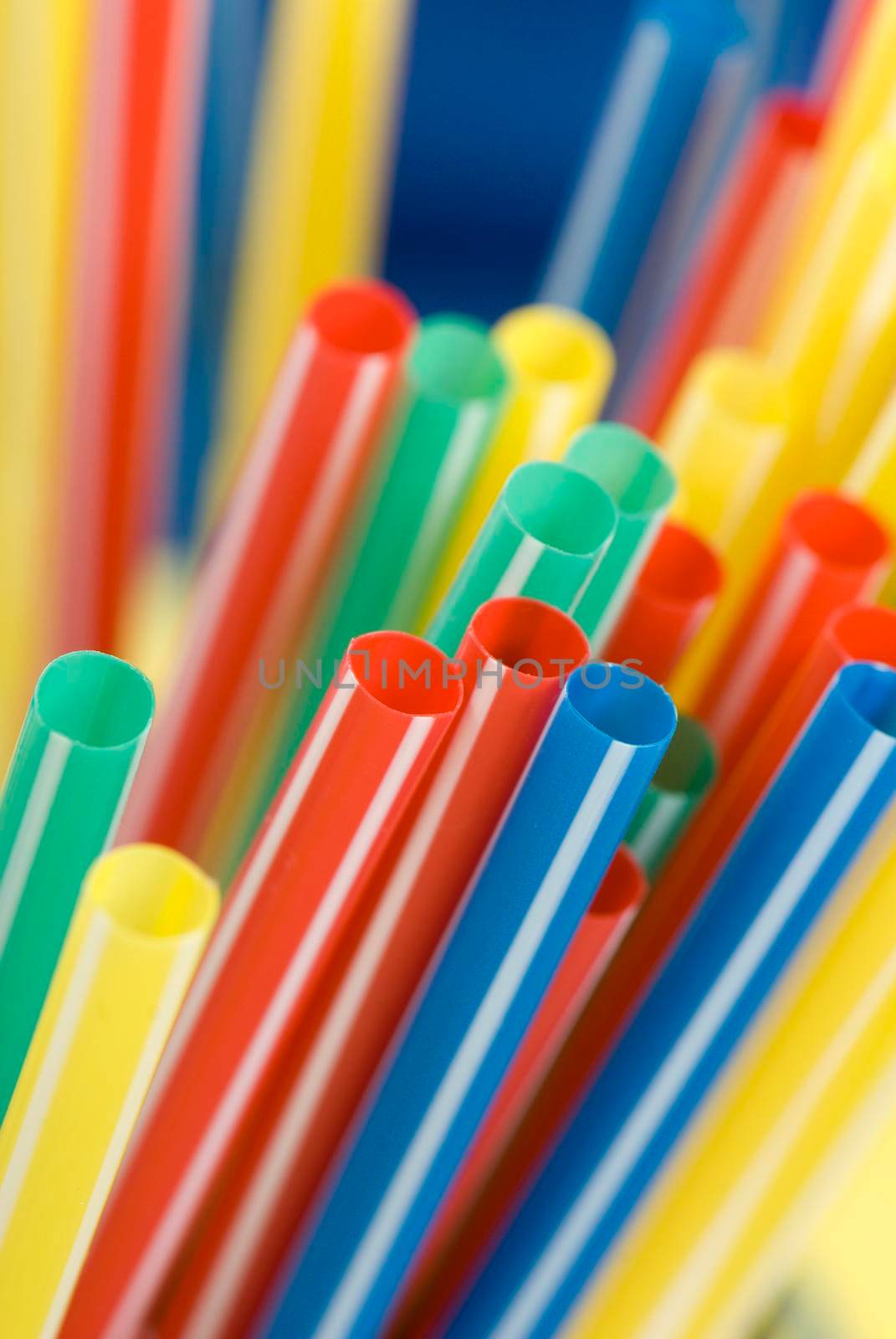Bunch of colorful drinking straws on a bright background