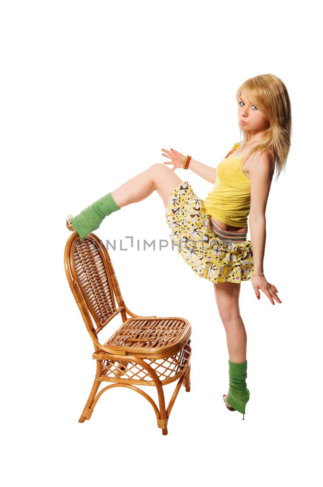 Beautiful stripper wearing yellow dress dancing with the chair isolated on white background