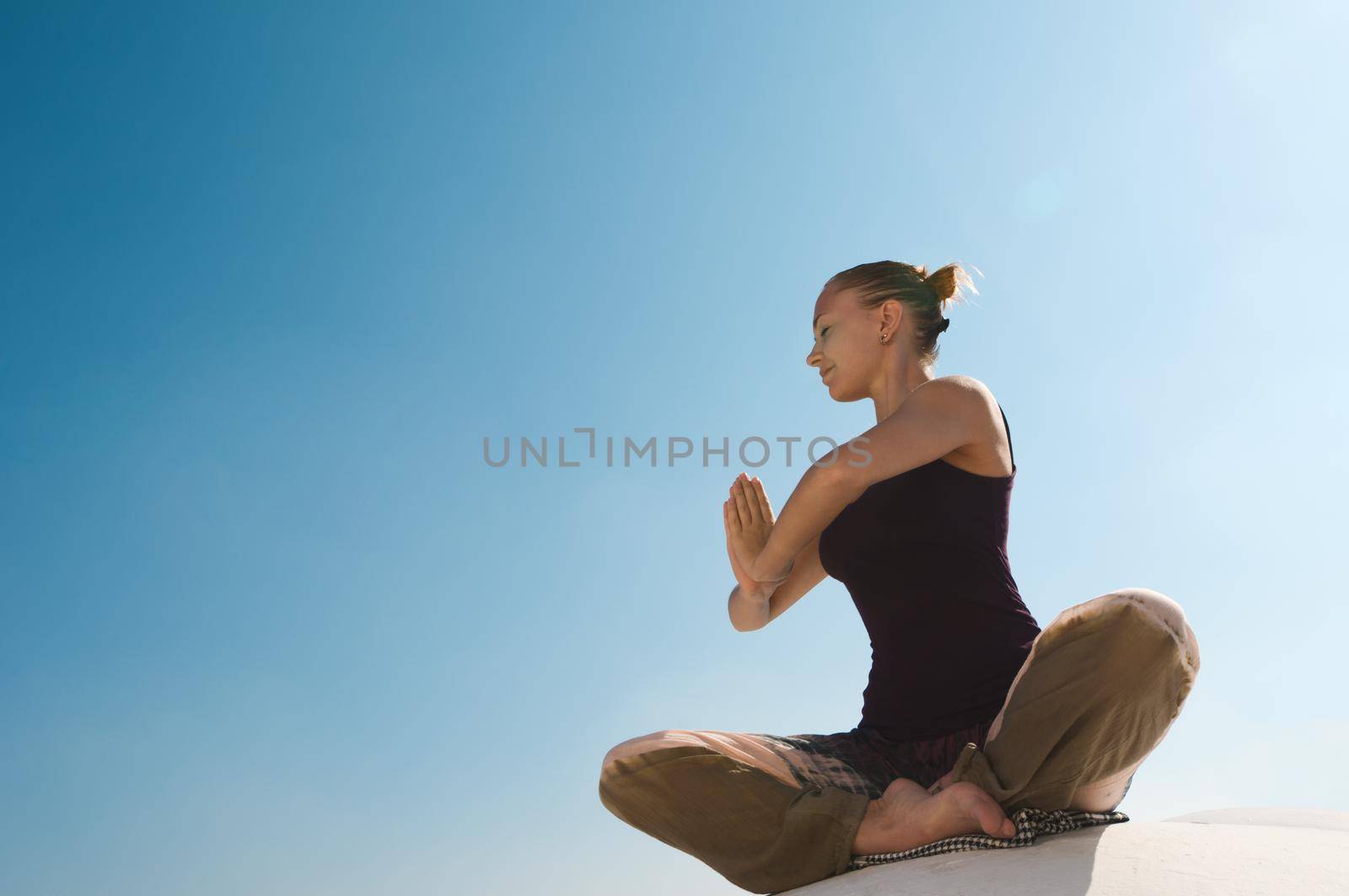 Attractive redhair woman practicing Vinyasa yoga outdoors