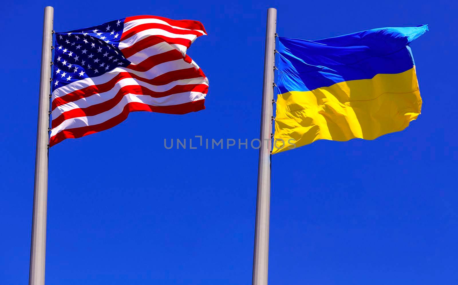 flags of the USA and Ukraine against bright blue sky