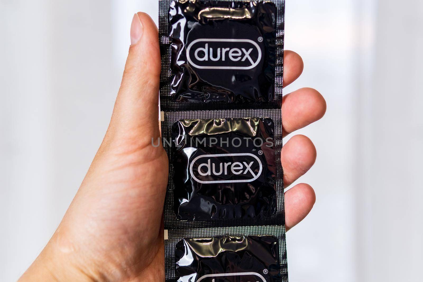 Tyumen, Russia-april 22, 2021: Durex condoms in hand. It is used for the prevention of sexually transmitted diseases. Health Concepts by darksoul72