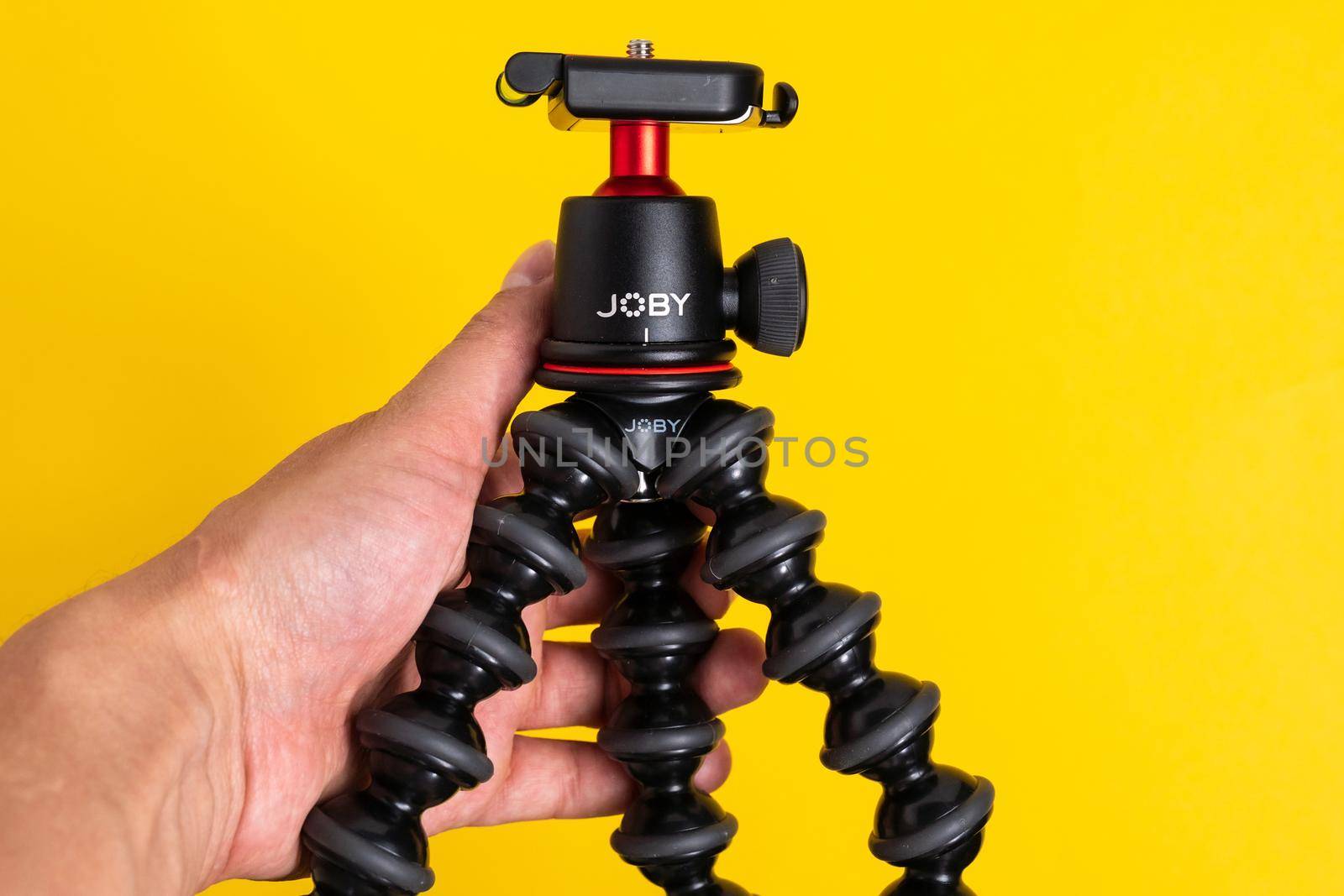 Tyumen, Russia-June 21, 2021: Flexible tripod Joby. Equipment for recording movies on a yellow background. by darksoul72