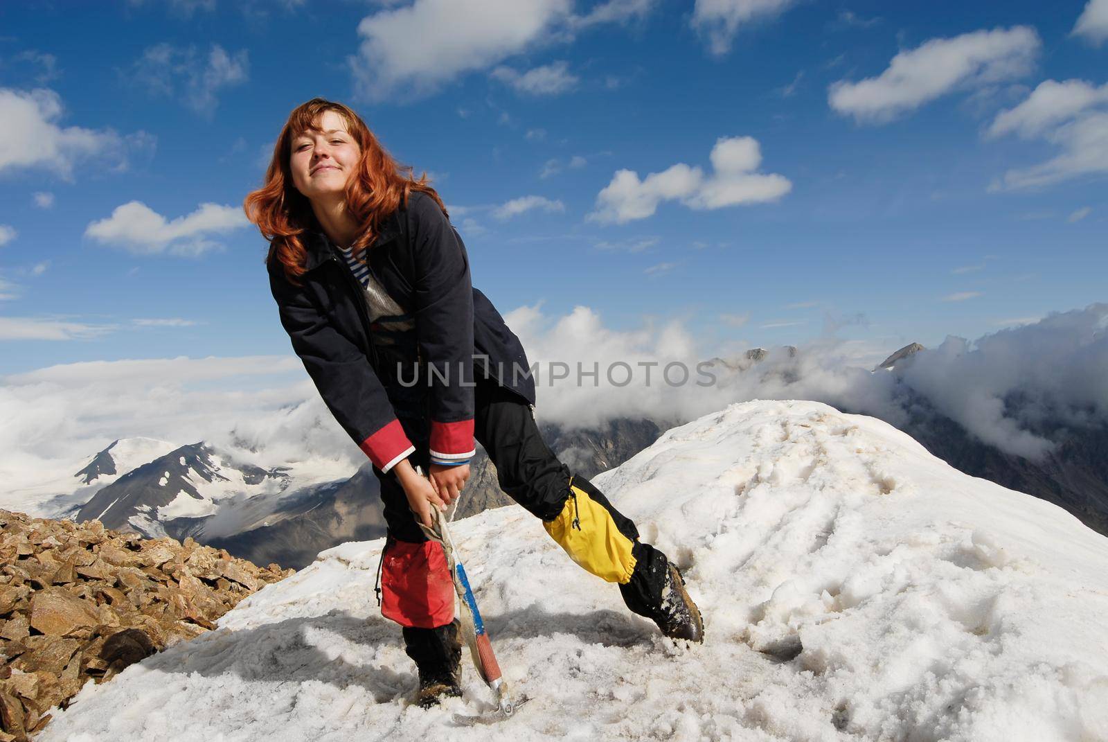 Mountaineer girl cheering at the top of a high mountain