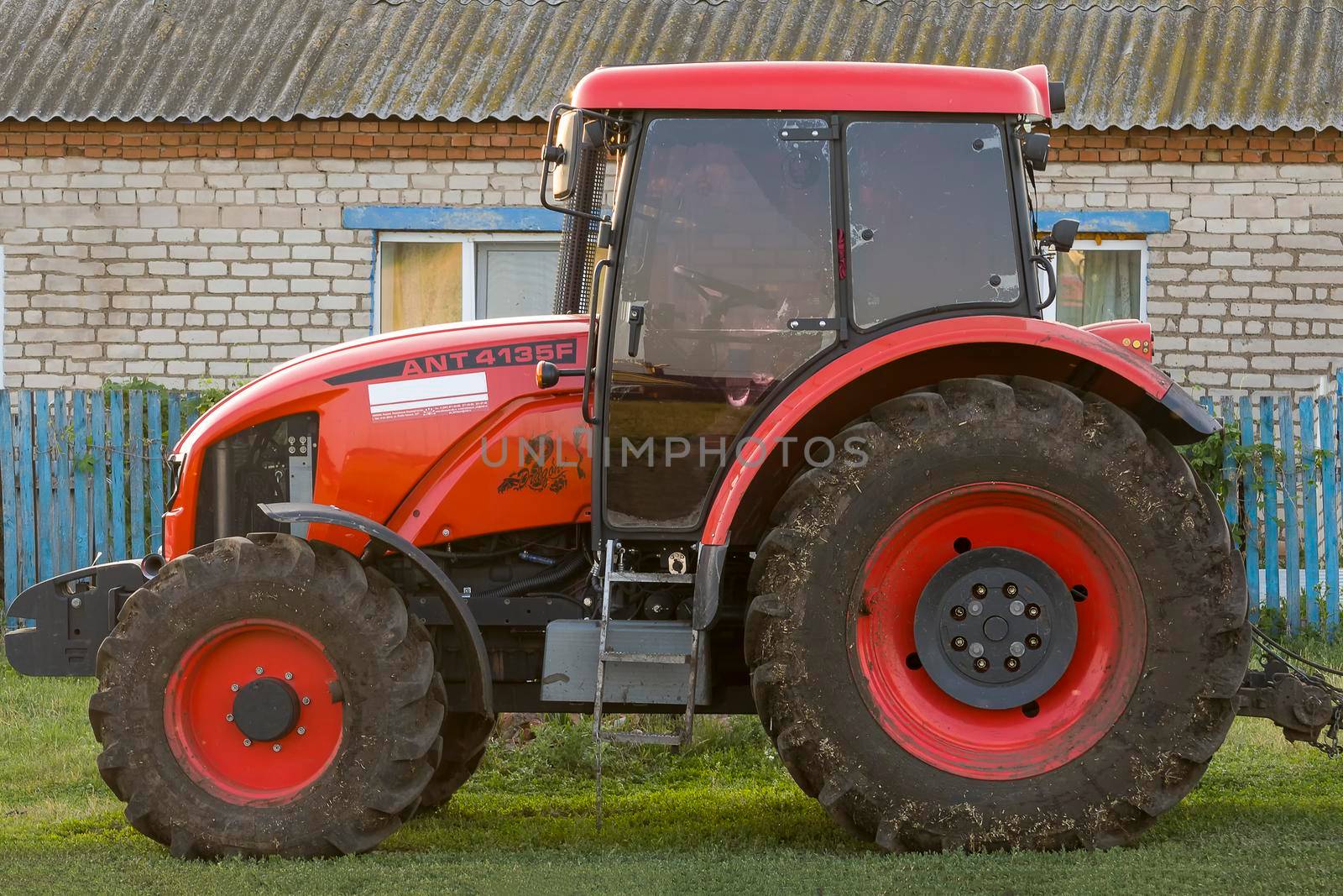 Red new wheeled tractor of medium size. Bashkortostan, Russia - 12 June, 2021. by Essffes