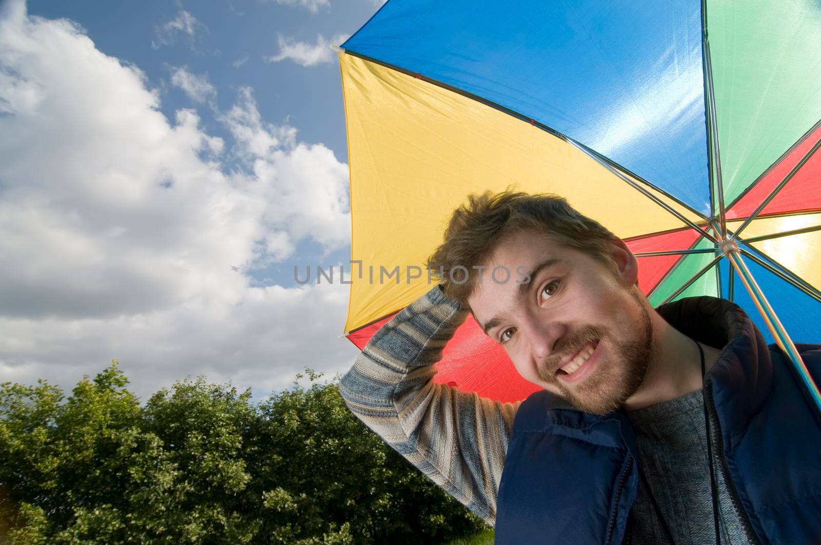 Young man in good mood with colorful umbrella.