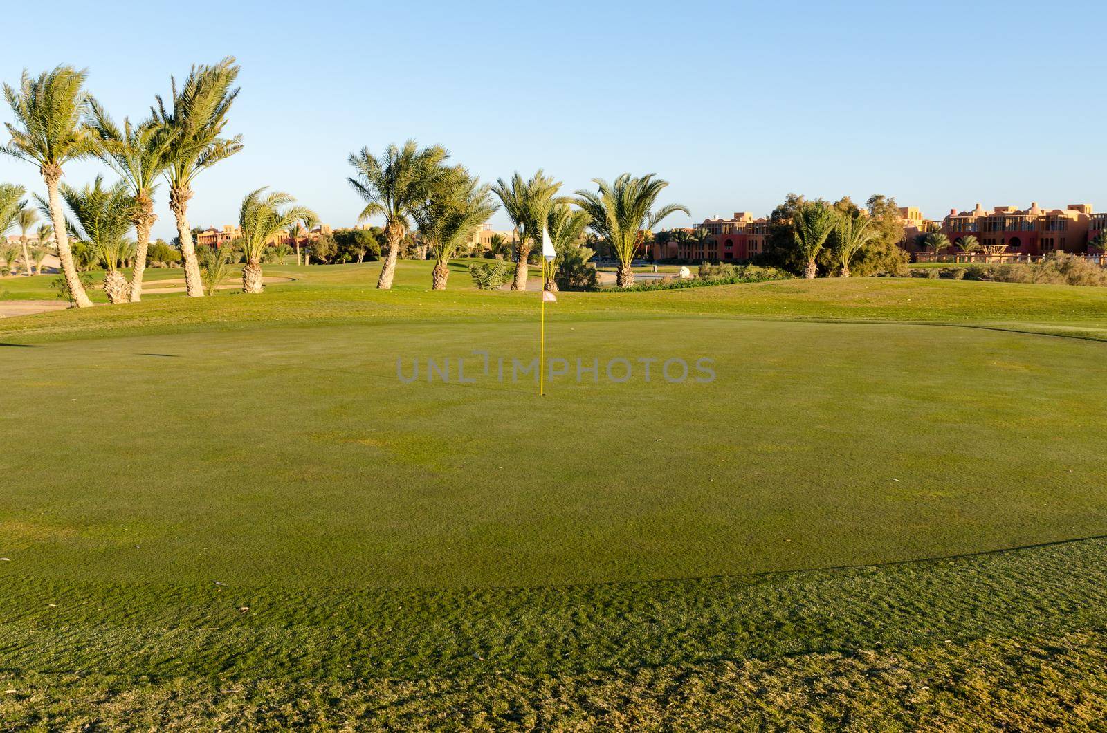 View on golf field with flag at sunset