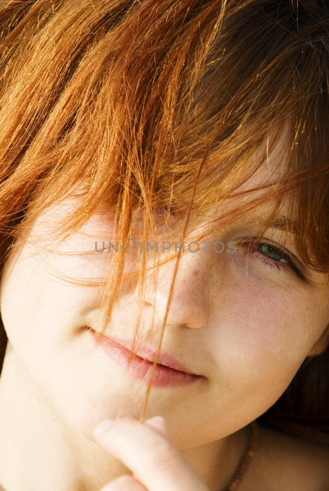 Closeup portrait of a red-haired girl with a tender look