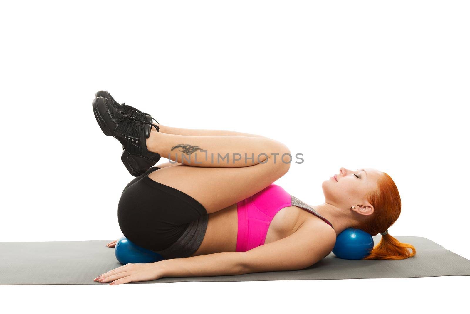 Young slim sensual red woman wearing sports bra practicing fitness