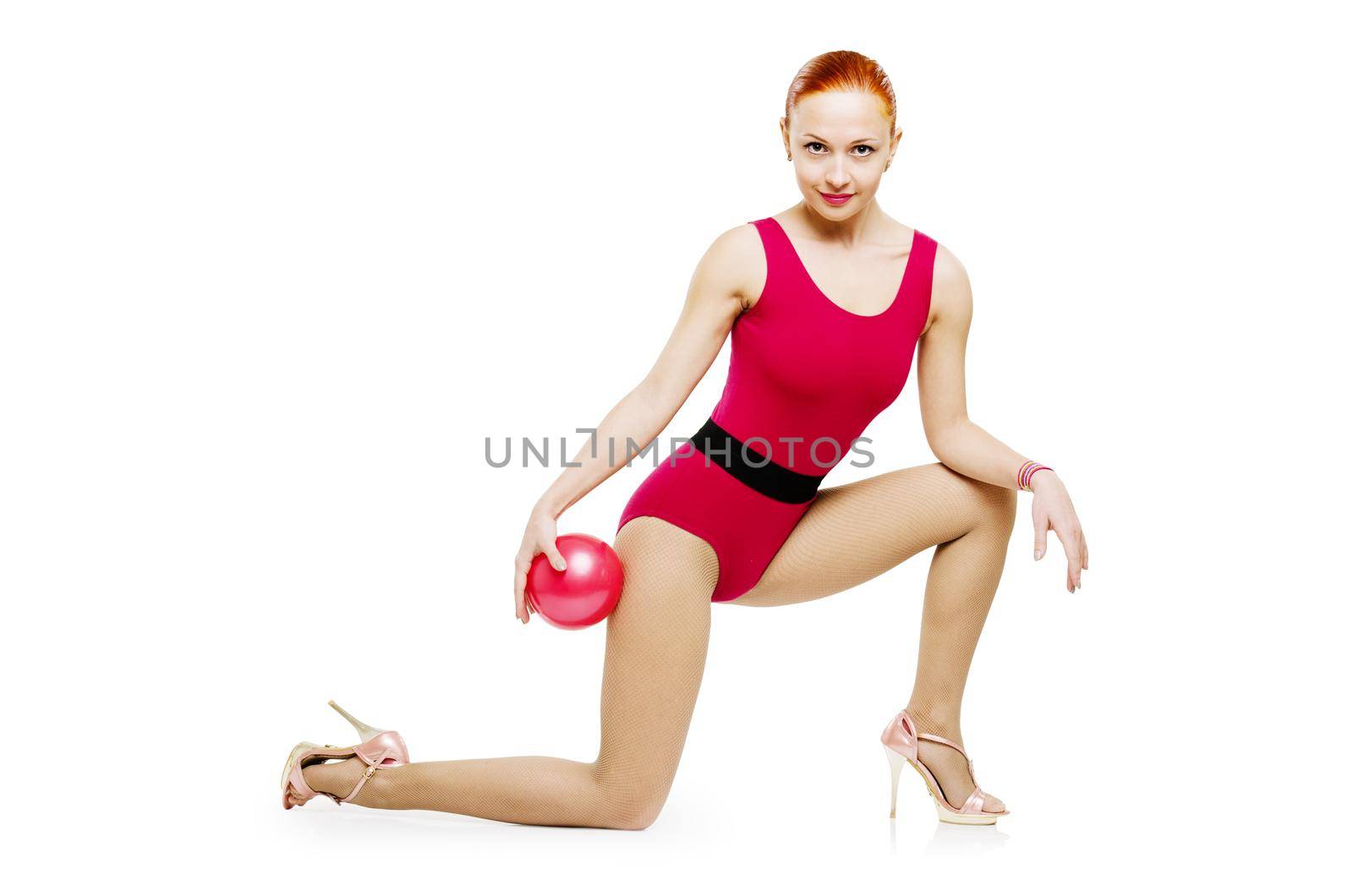 Beautiful fitness model posing with fit ball wearing high heels