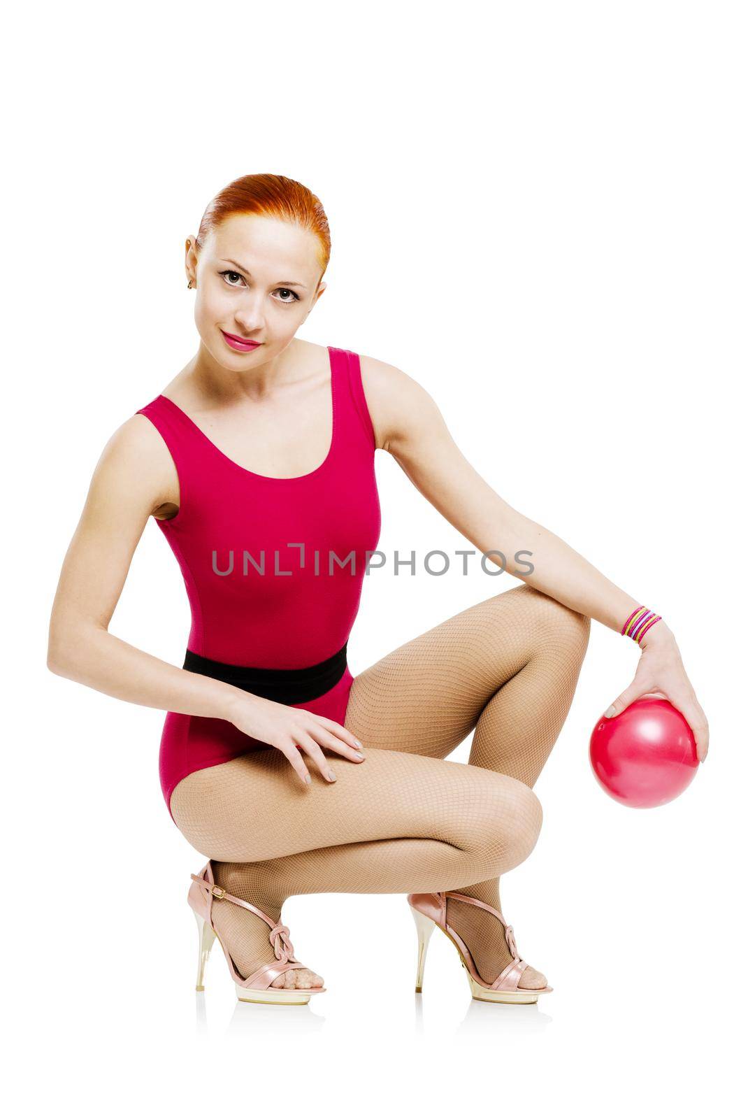 Beautiful fitness model posing with fit ball wearing high heels