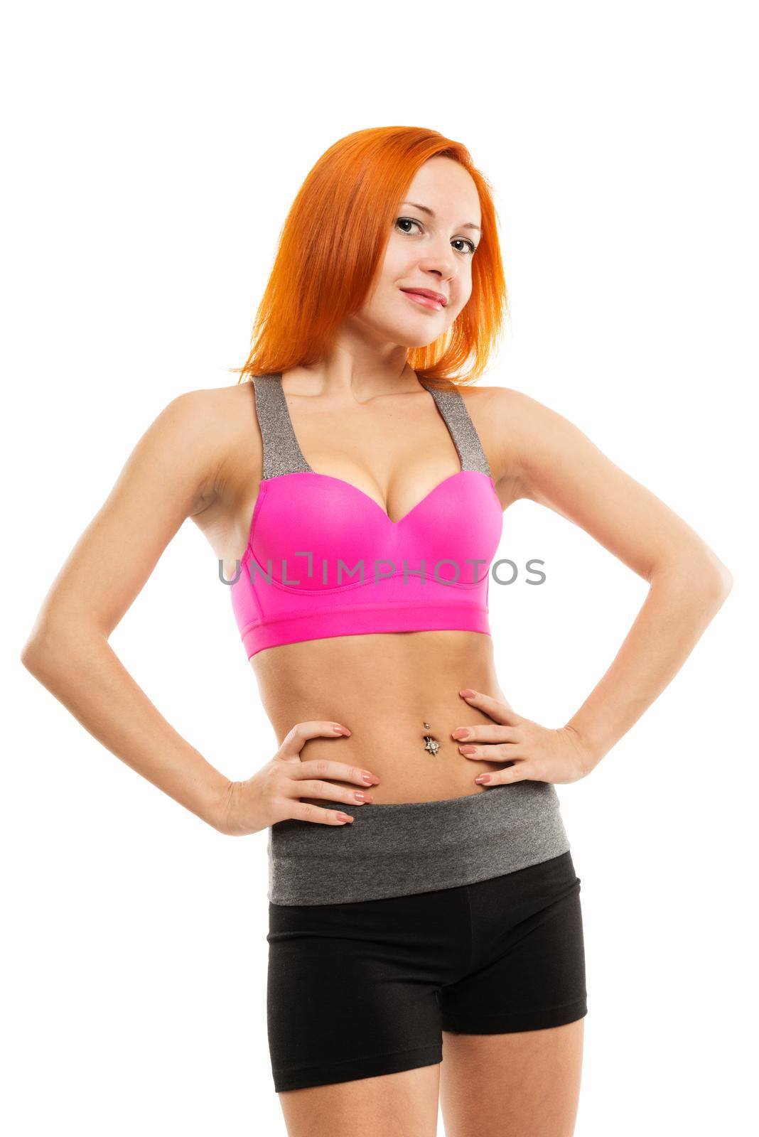 Young slim sensual red woman wearing sports bra practicing fitness