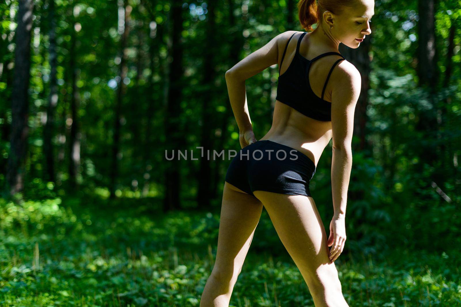 Sensuous slim woman doing fitness in park