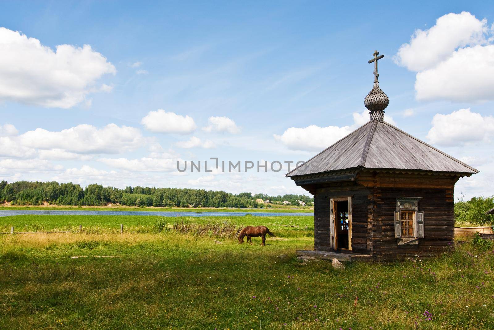 Countryside landscape with a wooden shrine, river and a horse over a blue sky