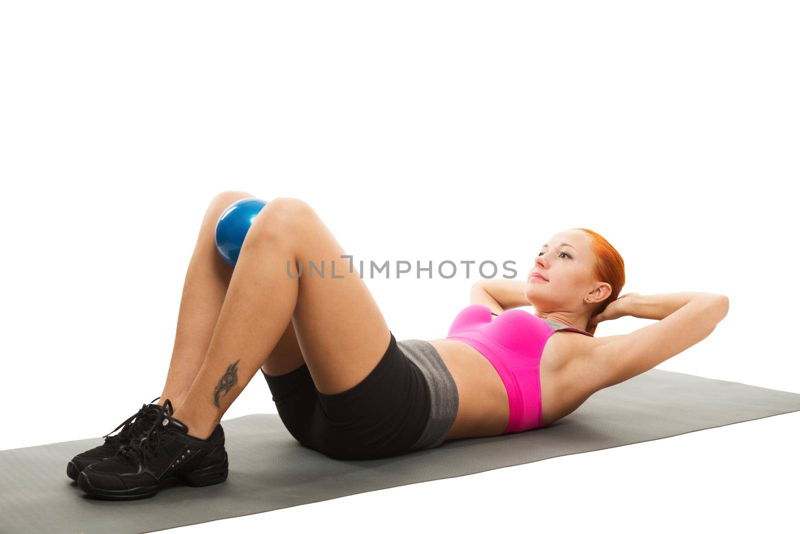 Young slim sensual red woman wearing sports bra practicing fitness